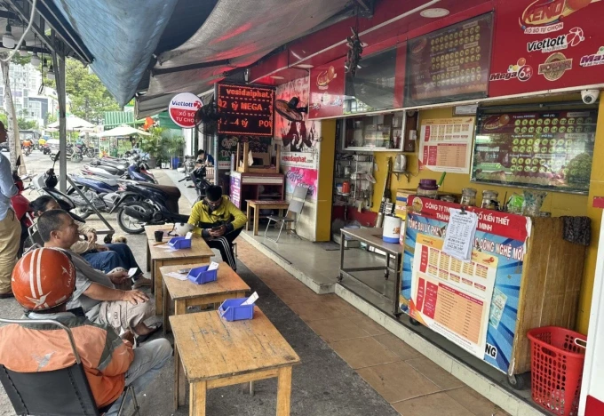 Một đểm bán hàng thu hút đông đảo khách tới dự thưởng xổ số Keno, dò trực tiếp trên màn hình lớn.