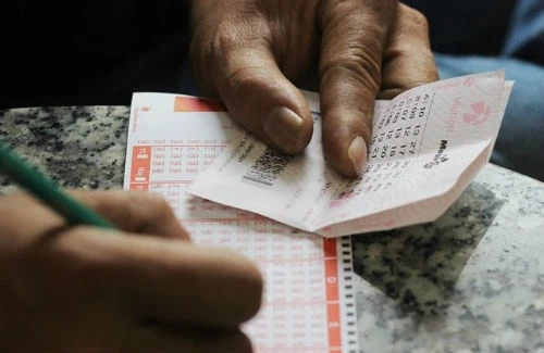 Một khách hàng mua vé số Vietlott tại TP HCM. Ảnh: PV.