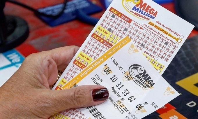 Một phụ nữ cầm tấm vé số Mega Millions hồi tháng 10/2018. Ảnh: ABC News.